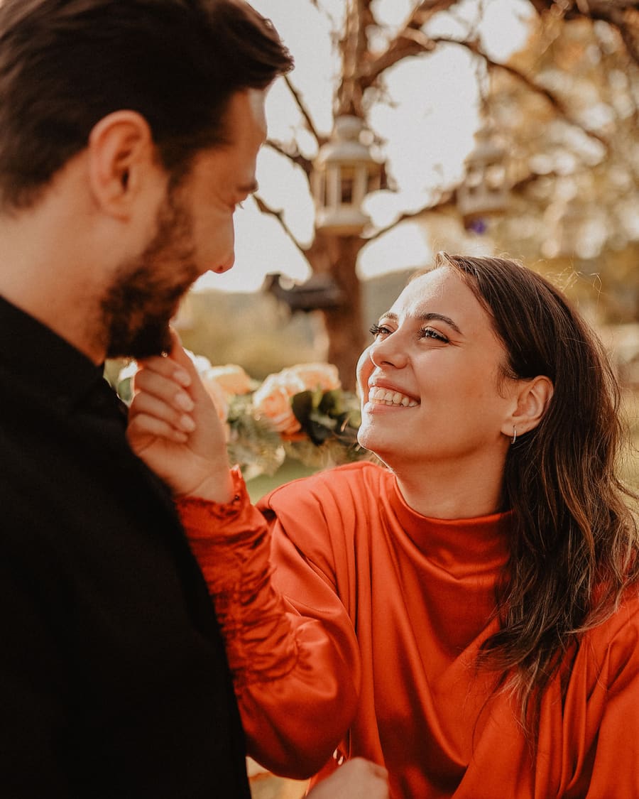 A woman laughing beside a warm male companion in an easy social moment.